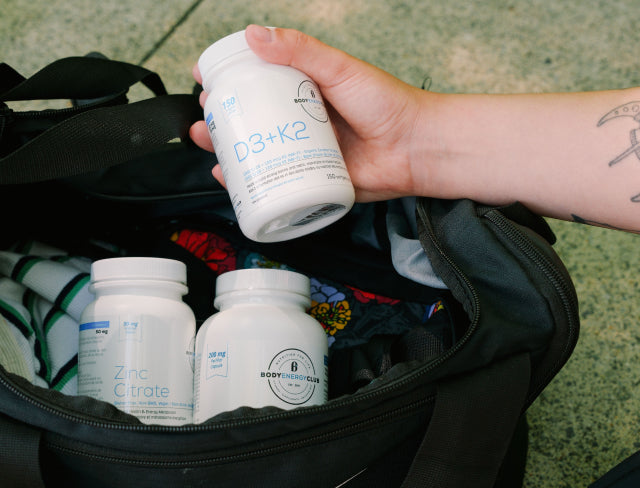 Body Energy Club Vitamins and Minerals - Zinc Citrate bottle and D3 + K2 bottle in a workout bag