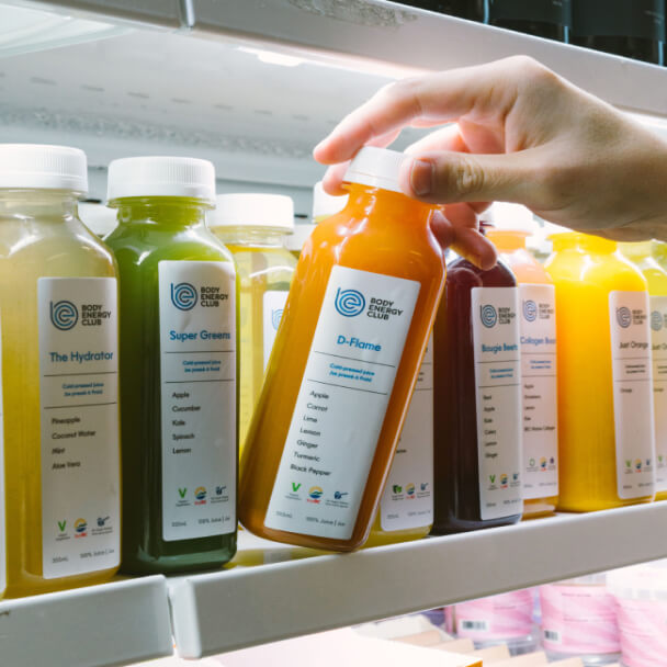 person selecting fresh pressed juice from the fridge