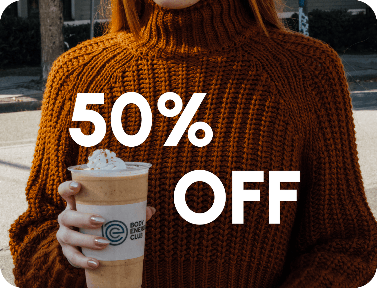 Woman in a brown sweater holding a 50% Off Pumpkin Patch Smoothie